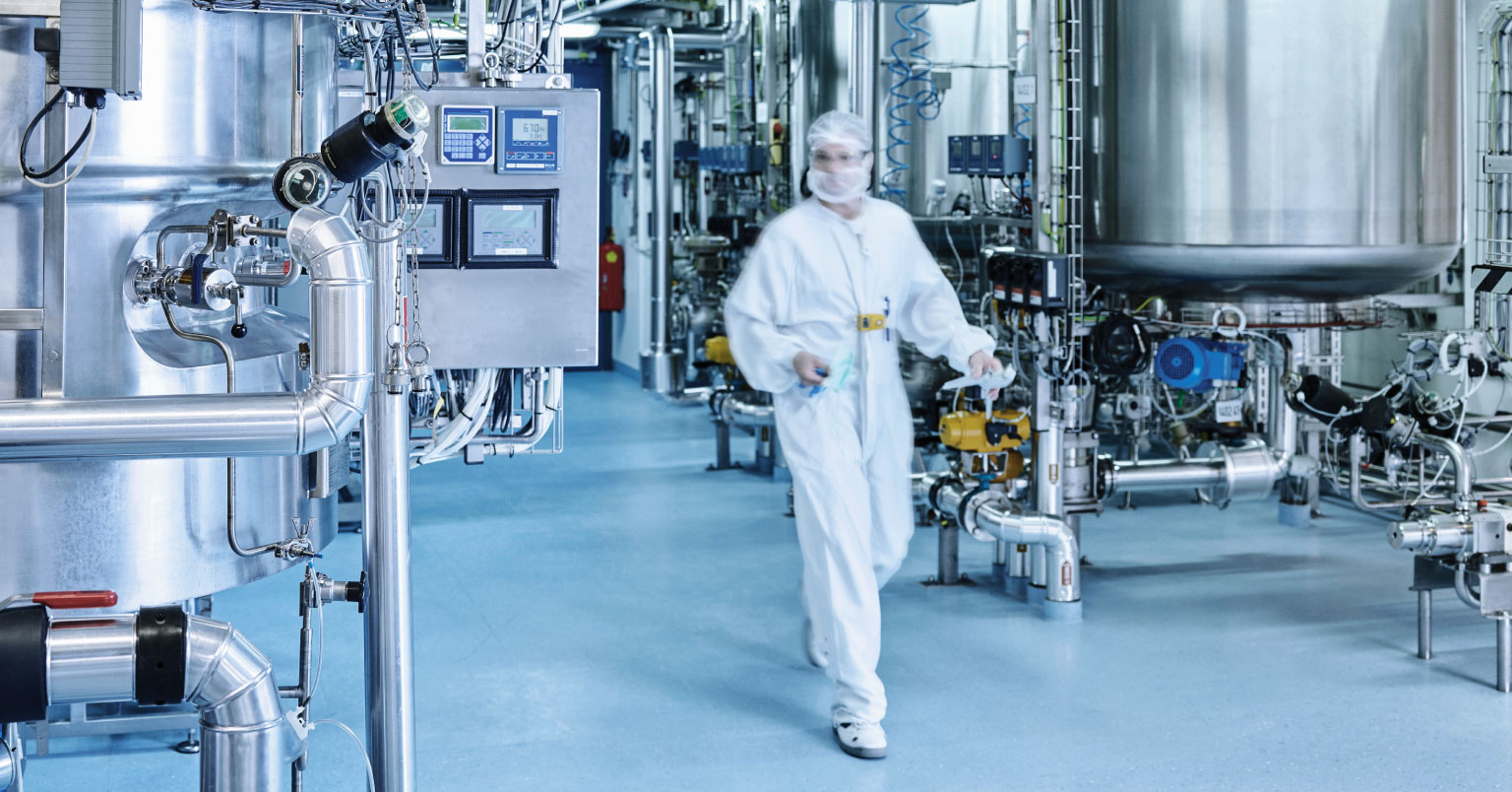 A chemical worker moving over to a control panel to one of Vortex's high-performing mixing solutions